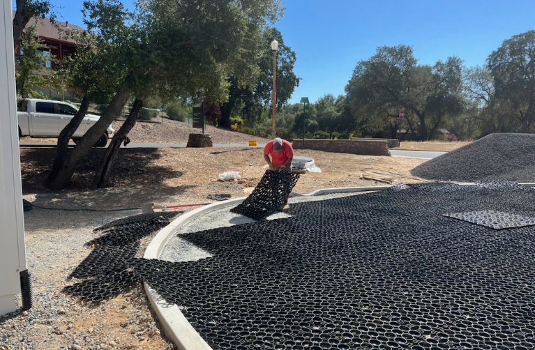 Worker installing permeable plastic pavers for a driveway