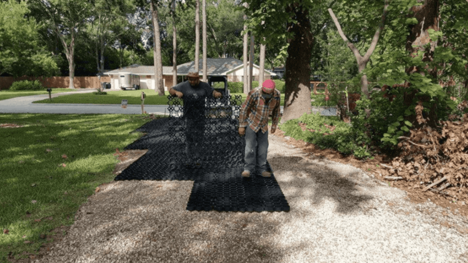 Workers install a permeable ground grid system on a prepared base layer