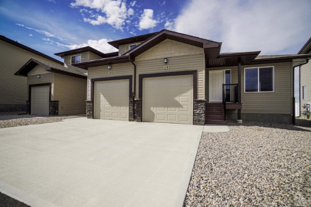 A concrete driveway in front of a house. 