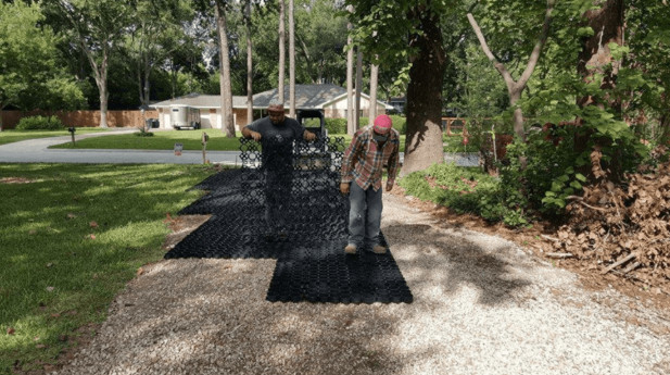 Workers prepare a yard for gravel. 