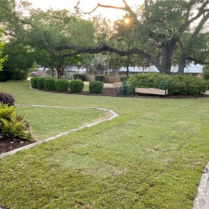 A modern grass driveway design outside of a garage. 