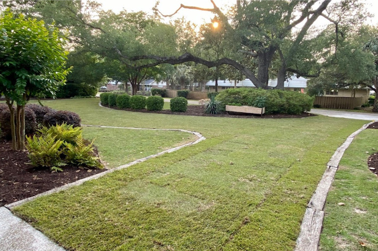 A modern grass driveway design outside of a garage. 