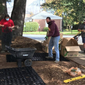 Workers prepare an outdoor area for permeable paver installation.