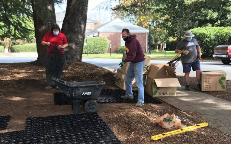 Workers prepare an outdoor area for permeable paver installation. 