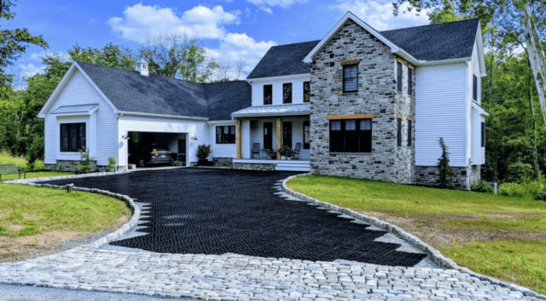 A two-story home with a permeable paver driveway designed for effective water drainage.