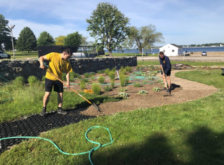 Workers prep the area before installing garden path pavers. 