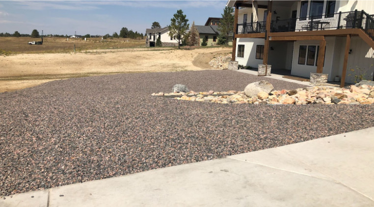An image of a two-story house with a gravel driveway. 