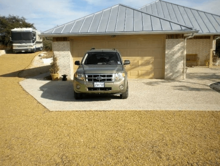 An image of a house with a curved gravel driveway. 