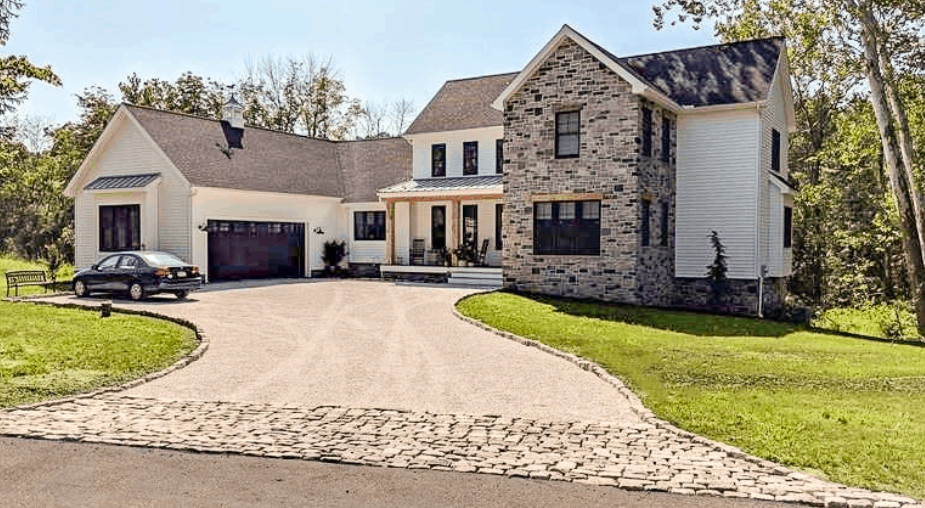 Modern farmhouse with a permeable paver driveway and stone entry apron.