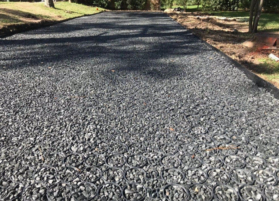 Permeable paver driveway filled with dark gravel.