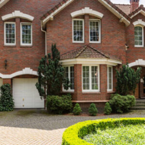 Brick home with a landscaped circular driveway featuring a central garden and statue.