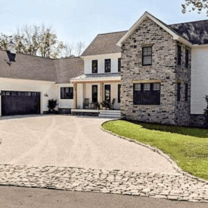 A two-story home with a permeable paver driveway designed for effective water drainage.