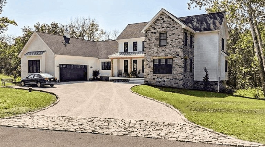A two-story home with a permeable paver driveway designed for effective water drainage.