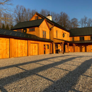 Gravel driveway leading to a modern rustic house