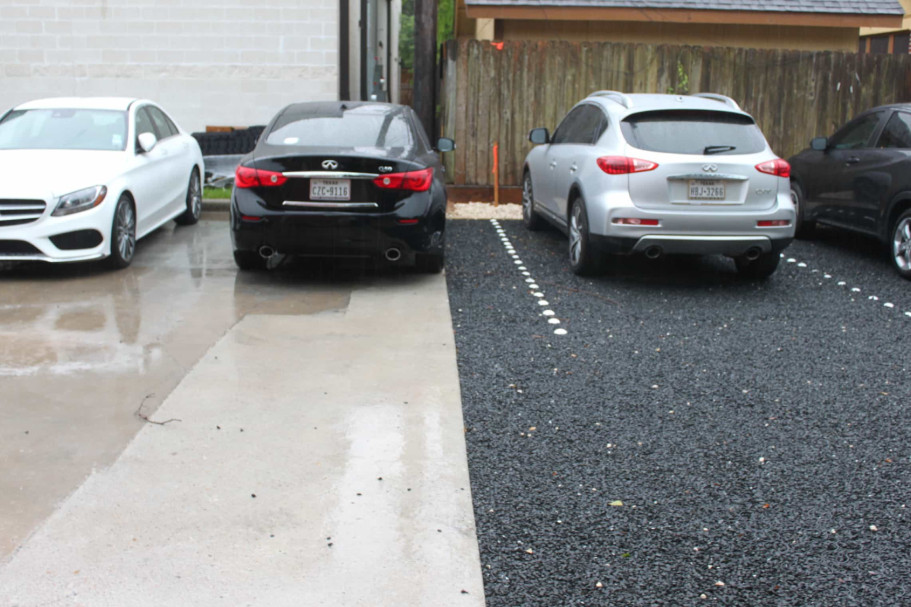 Parking pads with gravel and concrete surfaces, marked for multiple cars in a residential lot.