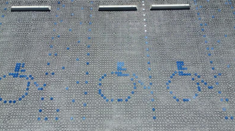 Parking bays, reinforced with a grid-paver, and identified by making the common wheelchair icon.