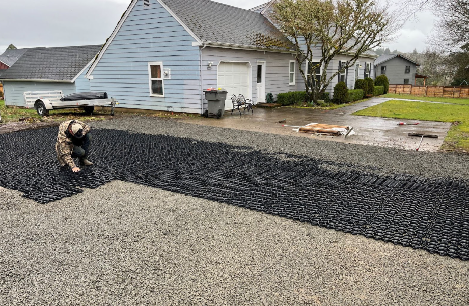 A ranch-style home with a permeable grid pavers driveway installation and stone infill.