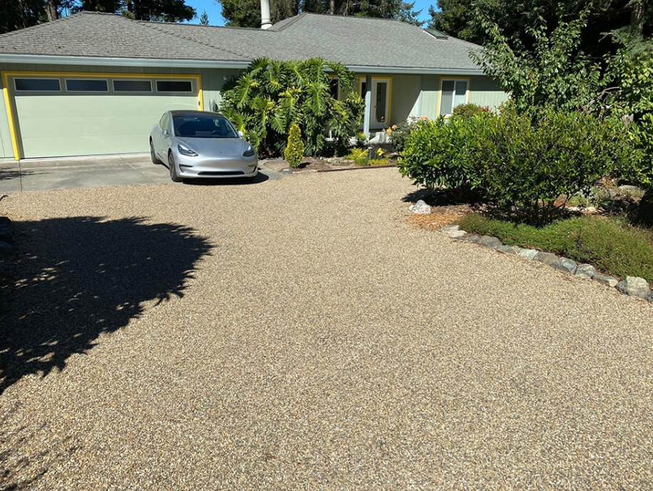Pebble driveway leading to a ranch-style home, designed to boost driveway curb appeal.