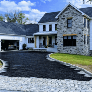 Home with a stone exterior and a stylish black driveway designed for strong driveway curb appeal.