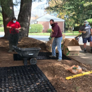 Volunteers installing grid panels as part of a permeable garden walkway project.