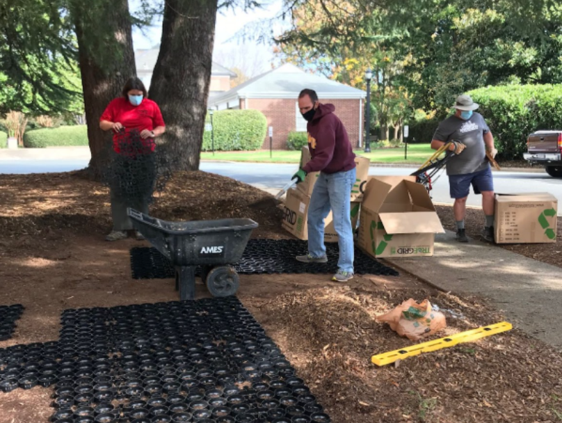 Volunteers installing grid panels as part of a permeable garden walkway project.