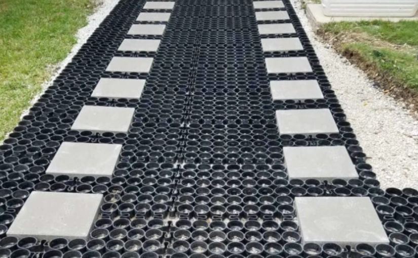 Plastic grid base with concrete pavers showing the benefits of permeable pavement for improved water infiltration and ground support.