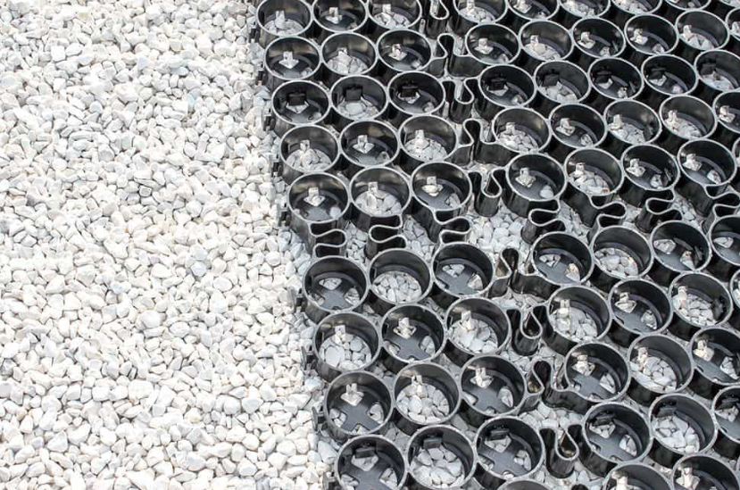 Close-up of 24x24 plastic pavers filled with white gravel for permeable ground support.