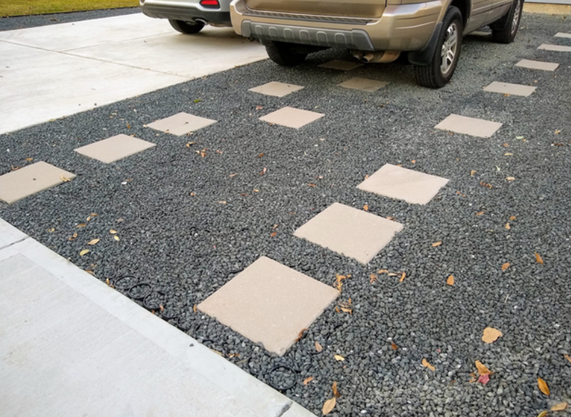 Gravel between pavers creating a stable driveway with a car.