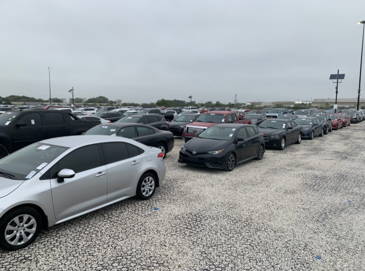 Parking lot with permeable pavers supporting rows of parked vehicles.