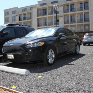 Parking area using low cost permeable pavers for vehicle support and drainage.