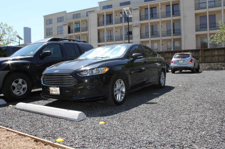 Parking area using low cost permeable pavers for vehicle support and drainage.