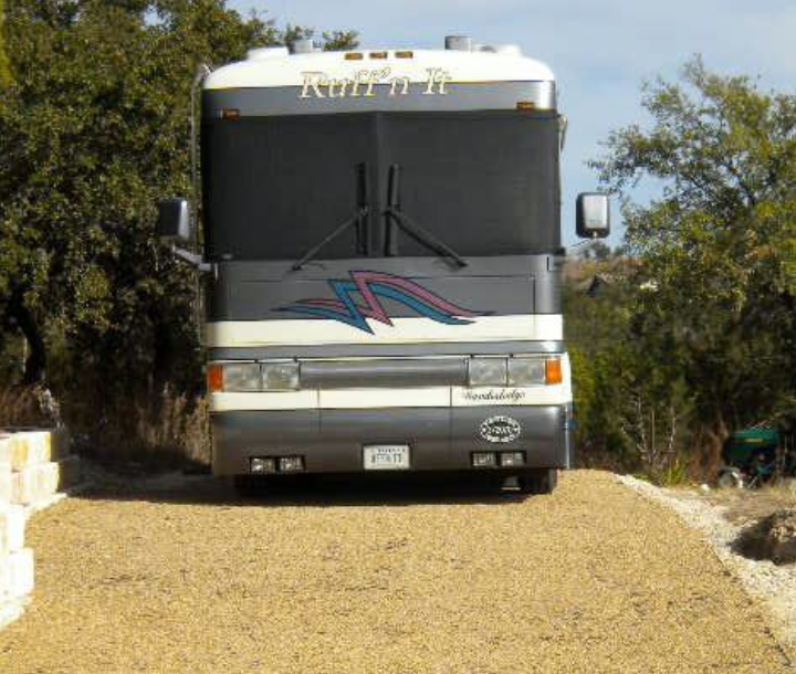 RV parked on a gravel driveway designed for drainage and stable vehicle access.