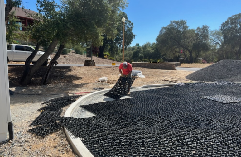 Worker installing a permeable paver system for stormwater management.
