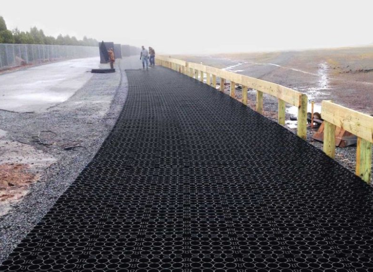 Permeable paver system installed along a roadway for stormwater drainage and erosion control.